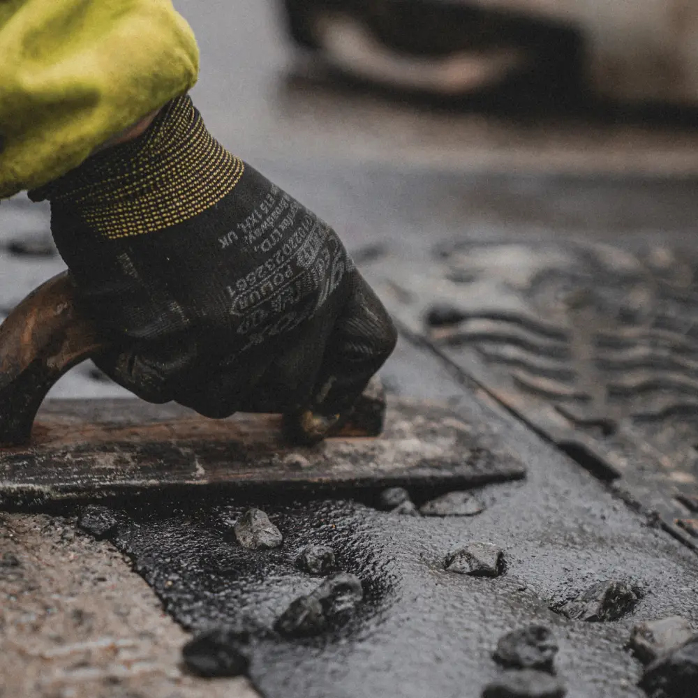 A photo of mastic asphalt contractors installing the IKO Pacopatch ironworks reinstatement system into a road surface in Piccadilly, London