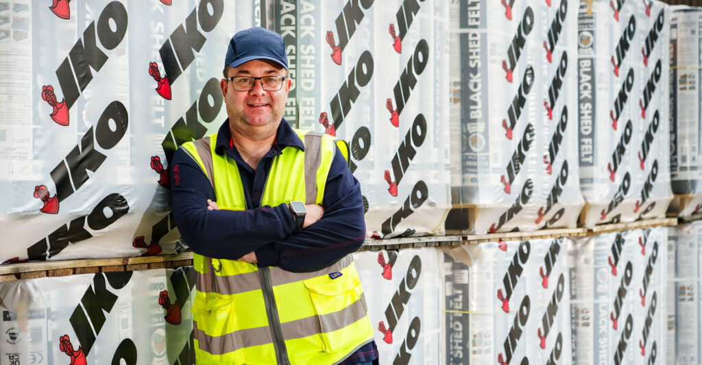 Partnering with IKO for sustainability and ESG blog - photo of an IKO employee in front of IKO products