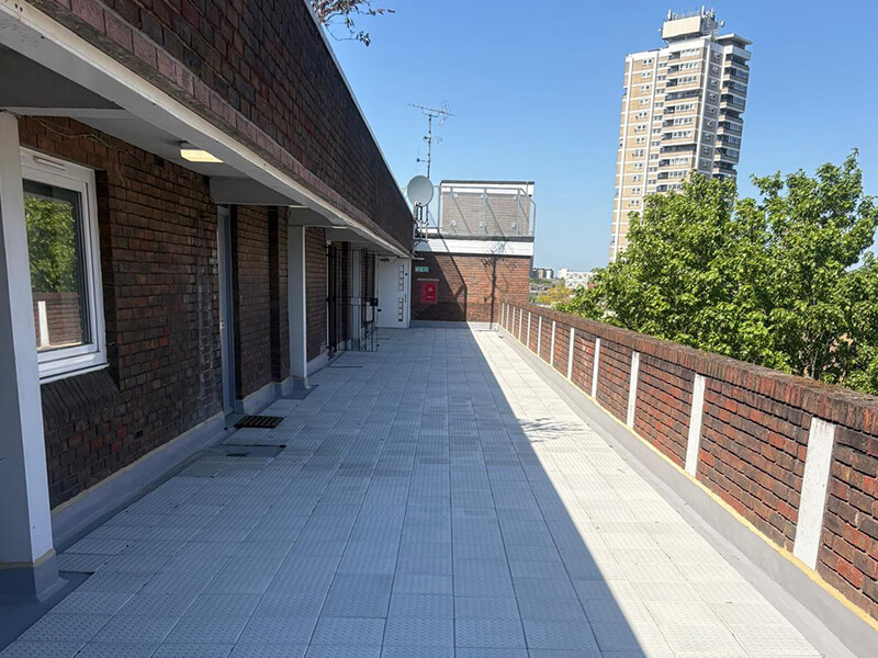 Refurbished balcony walkway deck at Couzens House, London, using IKO Permaphalt mastic asphalt waterproofing system