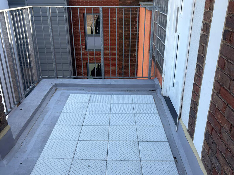 James Roofing installing IKO Permascreed LI and insulation on residential balcony walkway refurbishment project